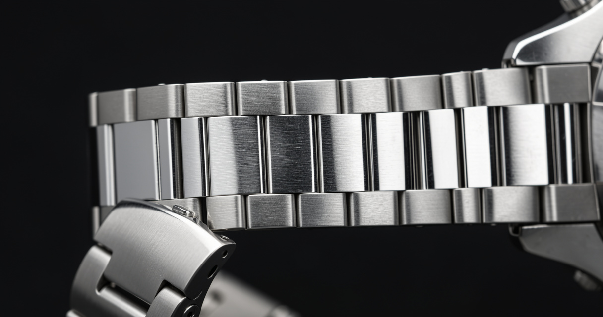 Detailed view of a stainless steel watch bracelet with brushed and polished links